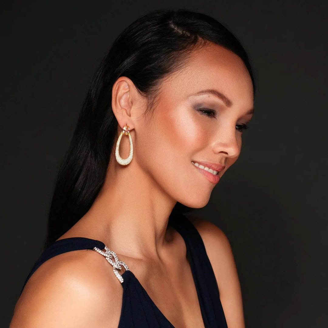 Long gold-colored drop earrings with zirconia