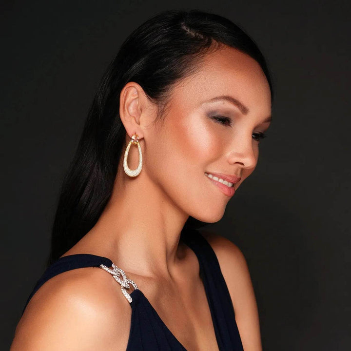 Long gold-colored drop earrings with zirconia