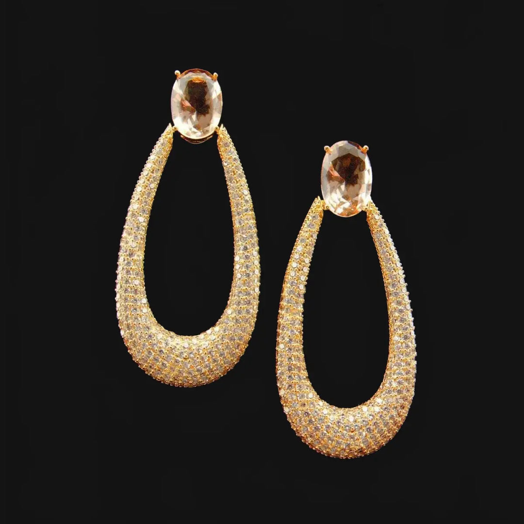 Long gold-colored drop earrings with zirconia