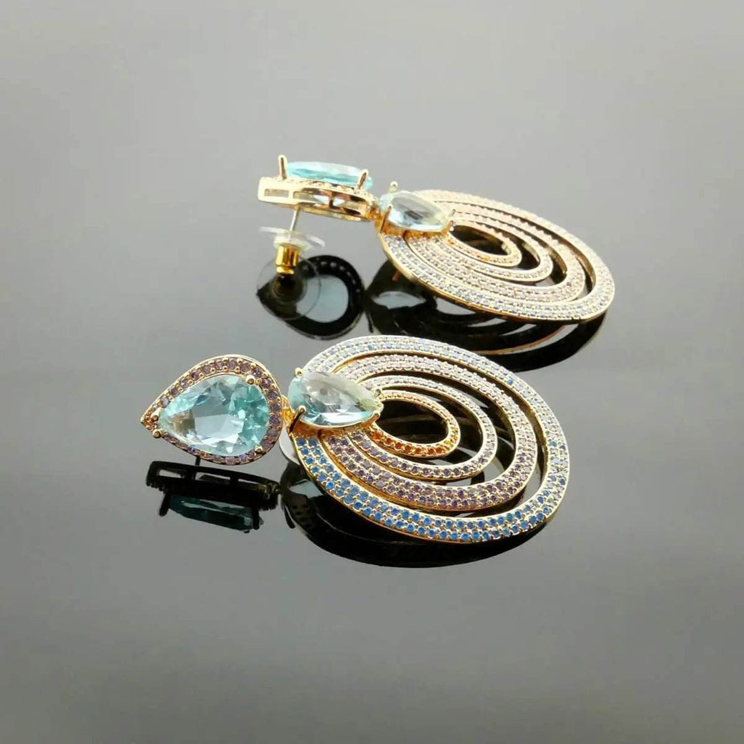 Rose gold colored earrings with turquoise colored zirconias