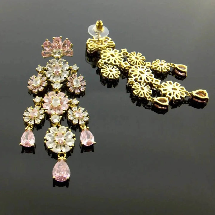 Gold-colored long flower-shaped earrings with pink zirconias