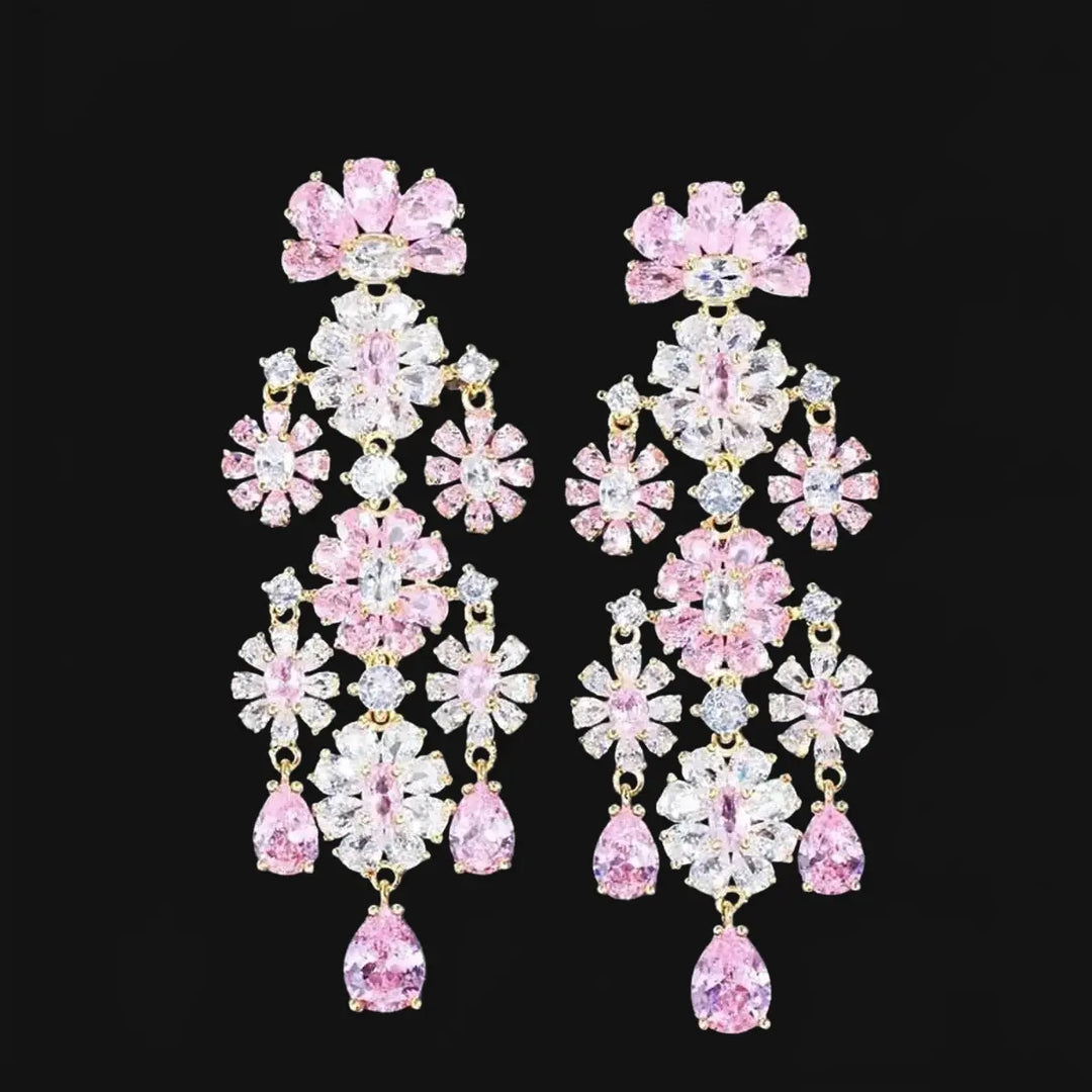 Gold-colored long flower-shaped earrings with pink zirconias